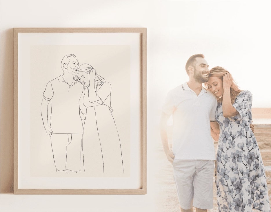 Een Miroar Line Art-afbeelding in een eikenhouten lijst naast een jong koppel op het strand